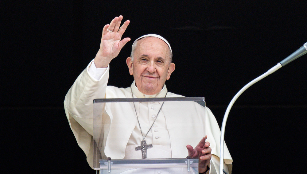 Papst Franziskus erhebt den Arm beim Mittagsgebet am Fenster des Apostolischen Palasts am 26. September 2021 im Vatikan