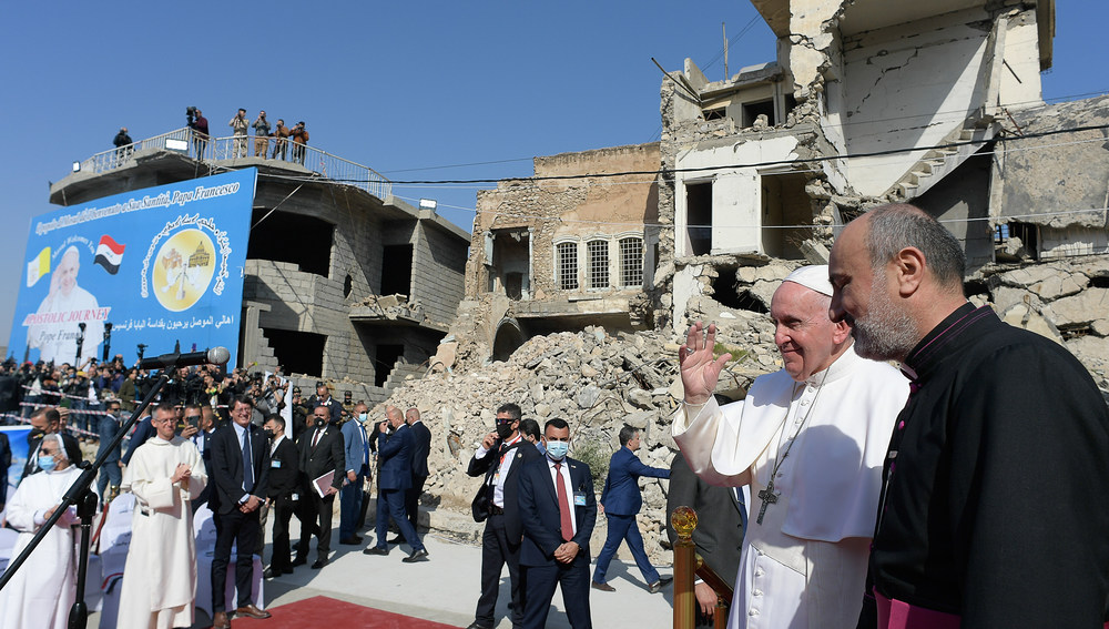 Papst Franziskus gedenkt in einer Zeremonie der Kriegsopfer in Mossul am 7. März 2021. Im Hintergrund stehen zerstörte Gebäude.