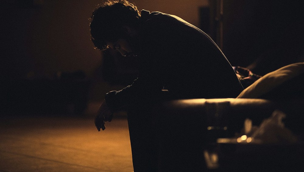 Mann im Dunkeln auf einer Bank