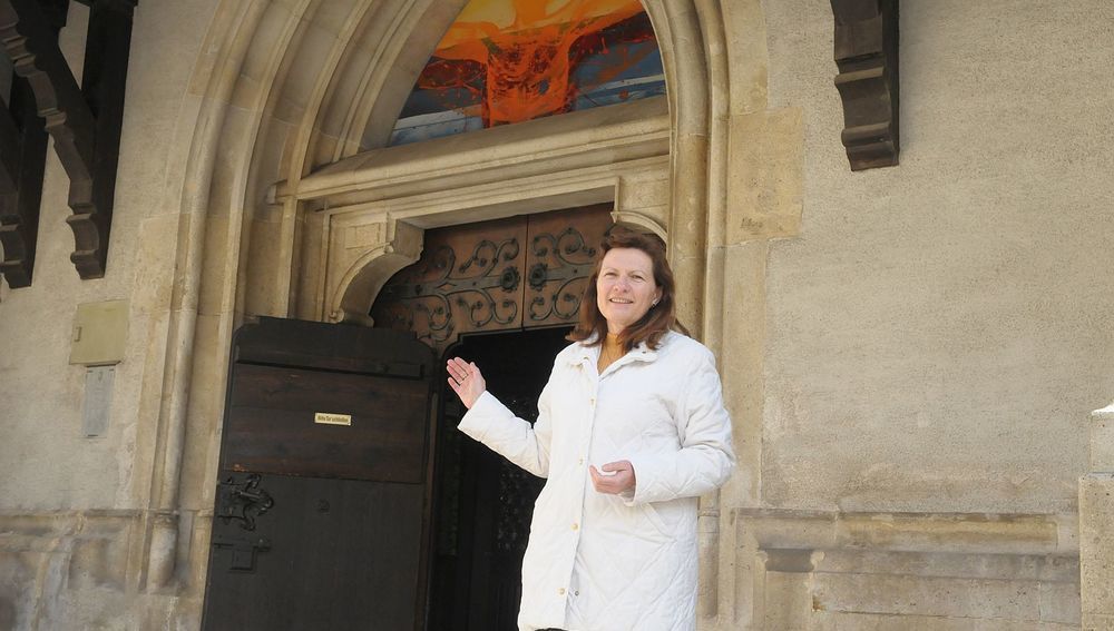 Offene Kirchentür mit einladender Person