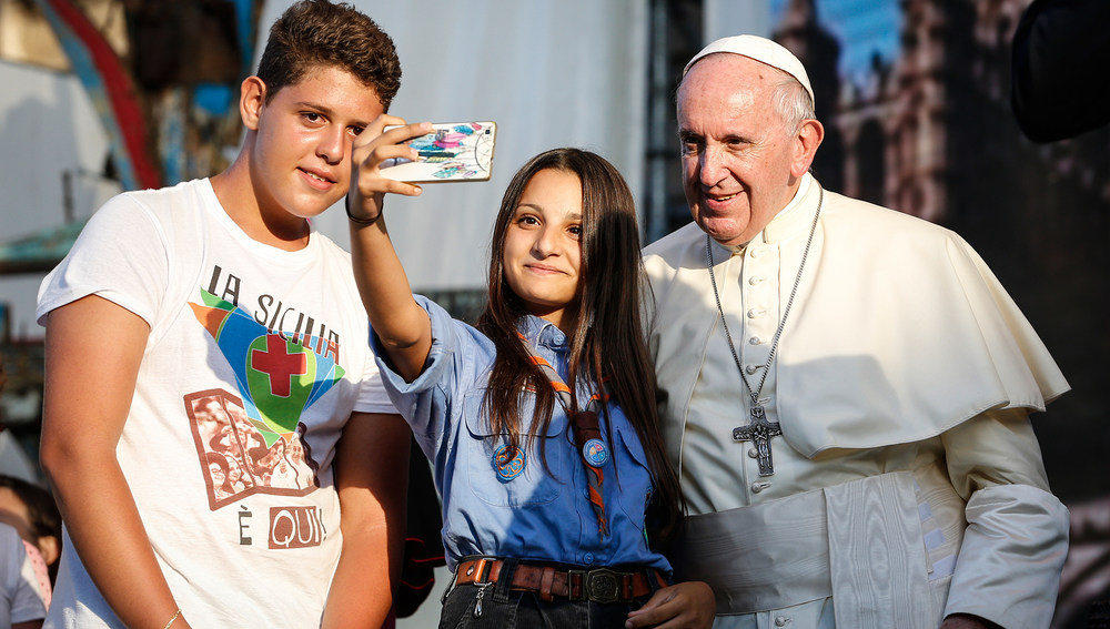 Eine junge Frau macht ein Selfie mit Papst Franziskus und einem jungen Mann am 15. September 2018 in Palermo.